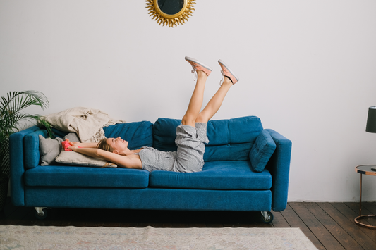a woman happily lying on a sofa relaxing