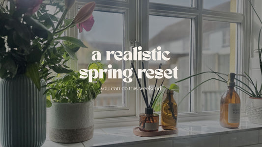 a spring scene with fresh flowers and plants on a window sill with a fresh scent reed diffuser for a spring reset