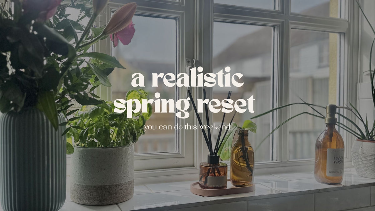 a spring scene with fresh flowers and plants on a window sill with a fresh scent reed diffuser for a spring reset