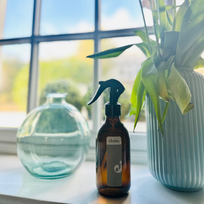 elena london signature e room spray styled on a windowsill with flowers