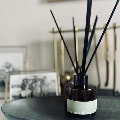 elena london reed diffuser with sticks in honey tobacco fragrance styled on shelf