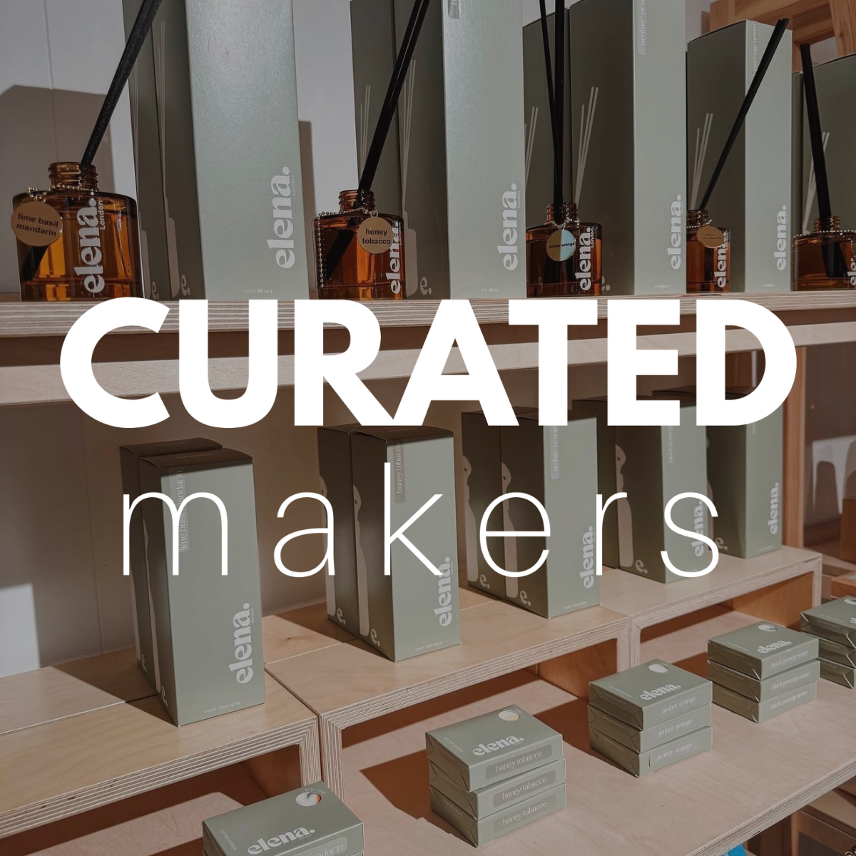 A retail display of 'elena London' reed diffusers and matching boxes on wooden shelves, with a large white text overlay reading 'CURATED makers'. The diffusers feature amber glass bottles with black reeds, and the boxes are a muted sage green-gray.